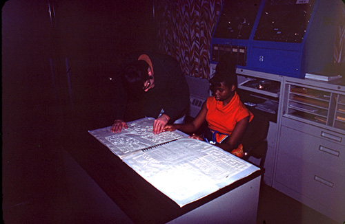 Student sitting on a desk using a tactile map of MSU